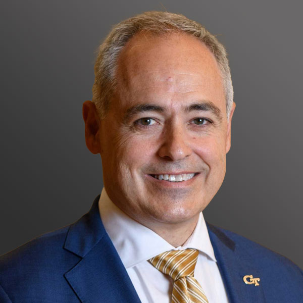 A man in a suit and tie smiling for the camera.