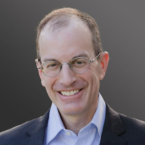 A man with glasses and a suit smiling. A man with glasses and a suit smiling.