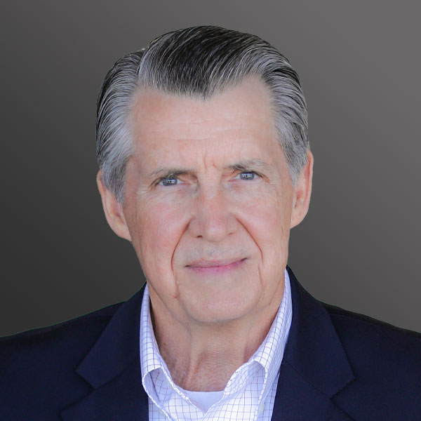 A man with grey hair and wearing a suit.