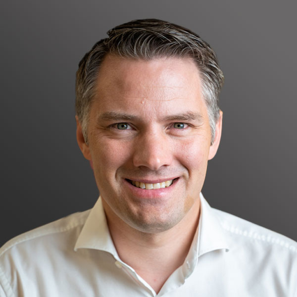 A man with grey hair and white shirt smiling. A man with grey hair and white shirt smiling.