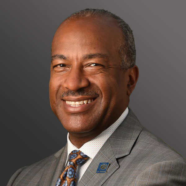 A man in a suit and tie smiling for the camera.