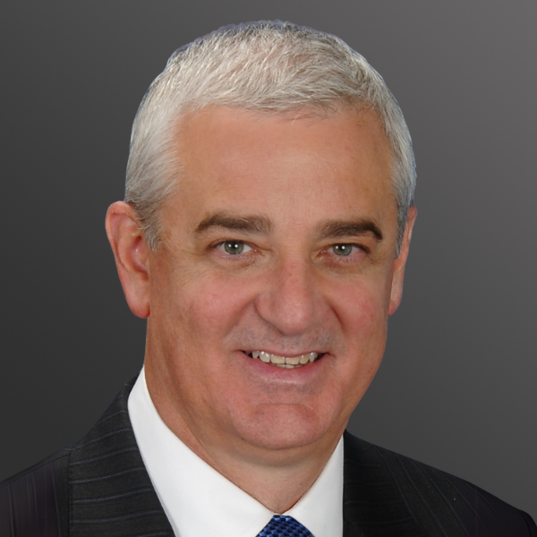 A man with white hair and wearing a suit.