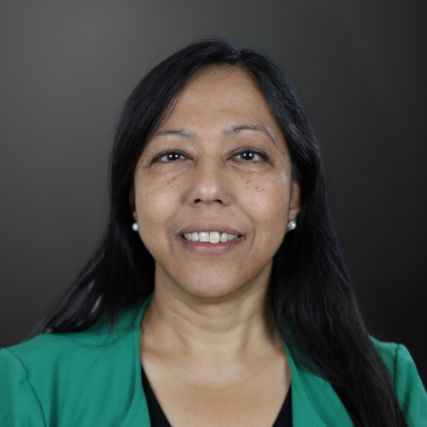 A woman in green jacket smiling for the camera.