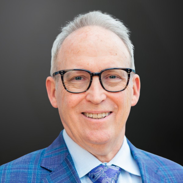 A man in a blue suit and glasses. A man in a blue suit and glasses.