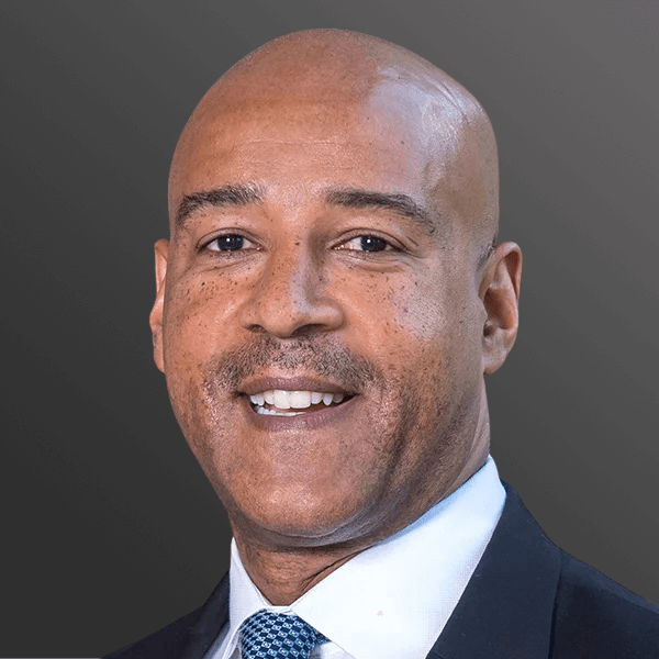 A man in suit and tie smiling for the camera.