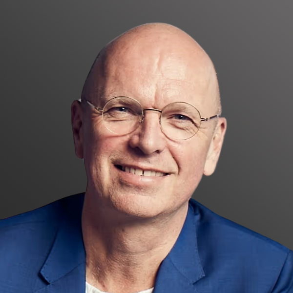 A bald man with glasses and a blue jacket.