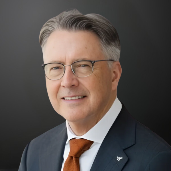 A man in suit and tie smiling for the camera.