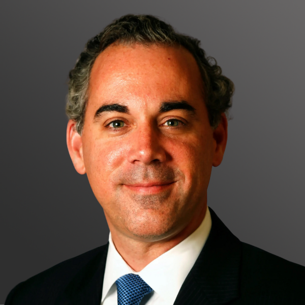 A man in suit and tie smiling for the camera.