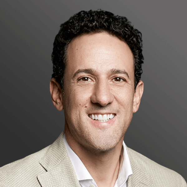 A man with curly hair and a white shirt is smiling. A man with curly hair and a white shirt is smiling.