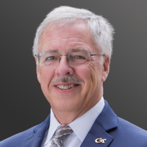 A man in a suit and tie smiling for the camera.