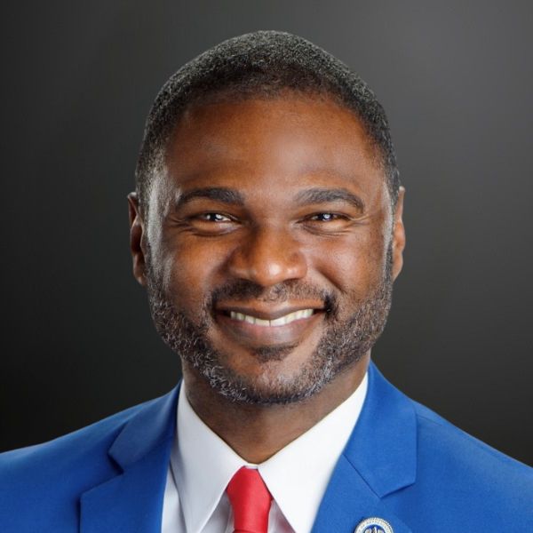 Smiling man in blue suit and tie.