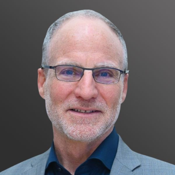 Man with glasses and a beard smiling.