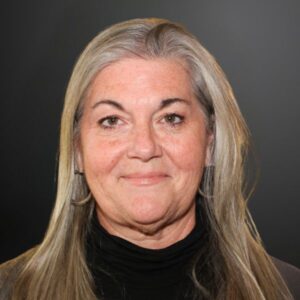Senior woman with long gray hair smiling.